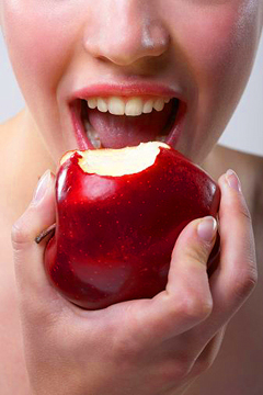 Young woman eating apple, close-up