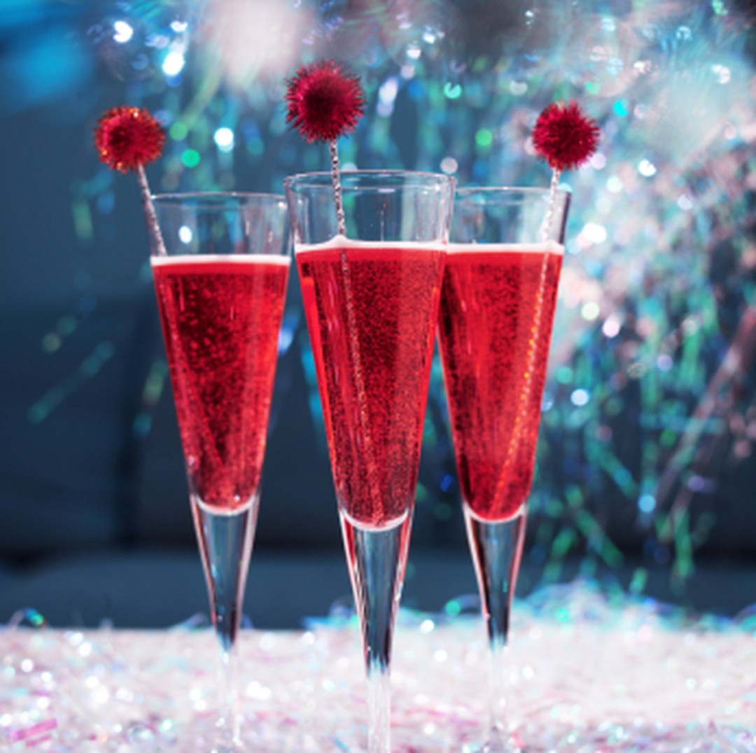 Champagne cocktails with tinsel and glitter in a festive party setting.f